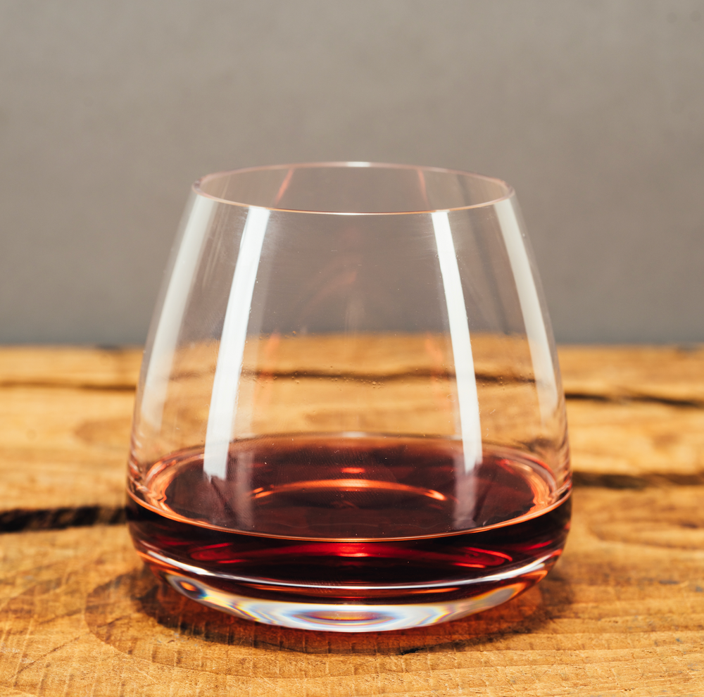 Gin rosso in bicchiere realizzato con botaniche selvatiche distillate in Italia 